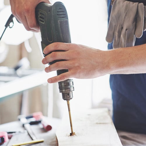 Handyman using a power drill for home repair service in San Francisco